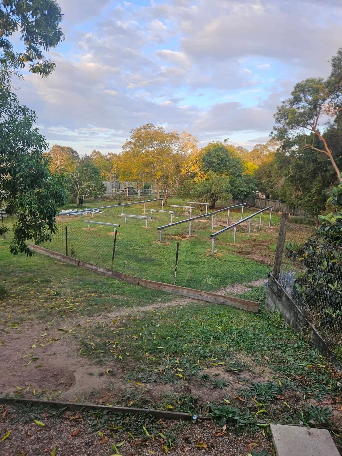 Kay’s prepared site and steel foundations, with an illustrated house outline and resale sign reflecting Expandify’s notice.