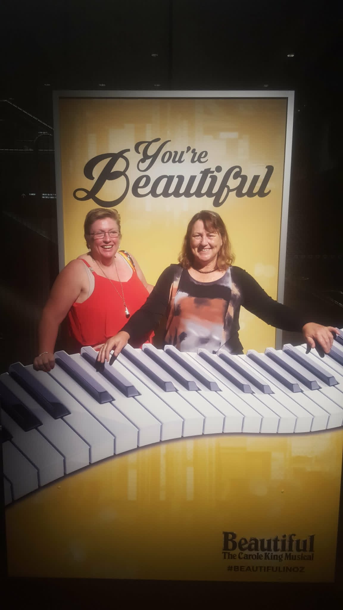 Kay and her friend Robyn smiling at a theatre display